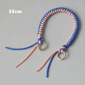 Detailed view of a 35cm blue and pink woven wax rope bag handle with gold metal rings
