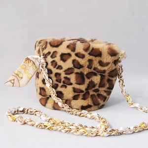 Detail of leopard faux fur bucket bag featuring metal chain woven with print silk scarf