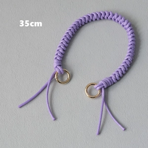 Detail view of a 35cm purple braided wax rope handbag handle with gold metal rings