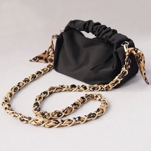 Detail of black ruched crossbody bag featuring leopard print scarf and gold chain strap