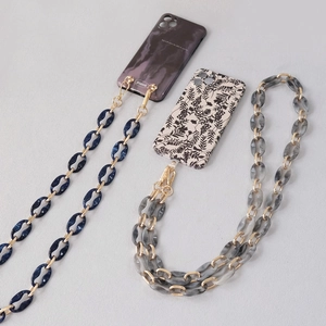 Detail of acrylic phone cross-body chain with marble resin links and gold metal clasps