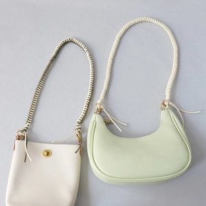 Detail of woven rope shoulder straps on white and light green faux leather handbags