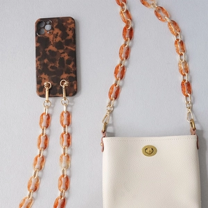 Tortoiseshell acrylic and gold chain strap set with cream leather bag and phone case