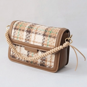 Detail of woven rope handle with gold hardware on a vintage plaid patchwork bag