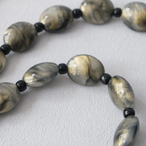 Macro detail of acrylic marble beads with gold glitter for bags and phone straps