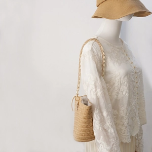 Detail of hand-woven straw bucket bag and matching sun hat set for summer vacation