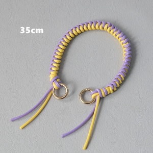 Detail view of a 35cm purple and yellow woven bag strap with golden metal rings