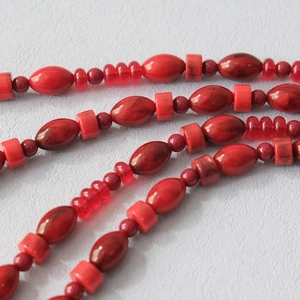 Macro detail of red acrylic beads with marble texture for fashion bags and phone chains