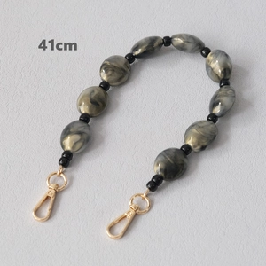 Detail of 41cm acrylic bead strap with grey marble pattern and gold metal buckles