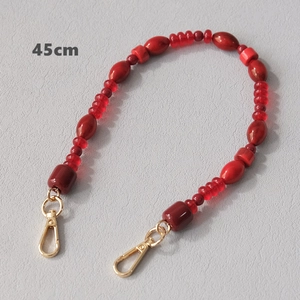 Detail of 45cm red acrylic beaded chain strap with golden metal lobster clasps