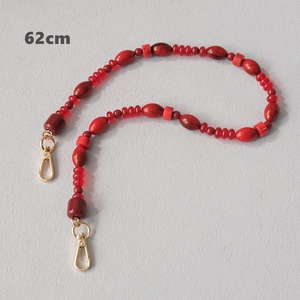 Detail view of 62cm red acrylic bead chain with various shapes and gold lobster clasps