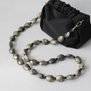 Black pleated cloud bag with marble resin bead strap and golden metallic clasps