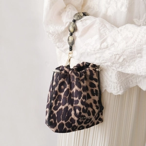 Detail of leopard print bucket bag featuring large resin marble beads and gold buckle
