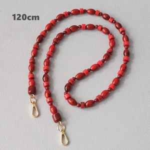 Detail view of 120cm red beaded strap with marble texture and golden lobster clasps