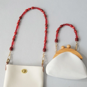 Detail view of white leather bags with fashion red acrylic beaded chain straps