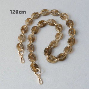 Détail de la chaîne de sac en résine ambrée de 120 cm avec anneaux dorés et mousquetons