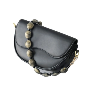 Black leather saddle bag with large marbled acrylic bead strap and gold metal hardware