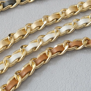 Detail of woven leather and gold chain straps in black, champagne, white, and brown
