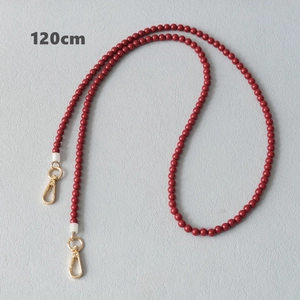 Détail de la bandoulière en perles acryliques rouge foncé 120 cm avec fermoirs dorés