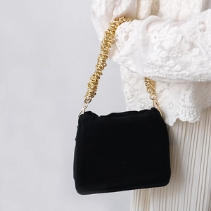 Détail de la chaîne dorée épaisse sur un sac à bandoulière noir plissé en daim
