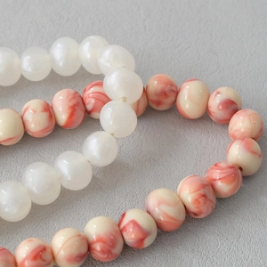 Macro detail of red marble acrylic beads and white pearls for stylish shoulder bag chains