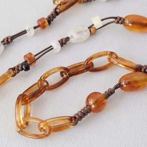 Detail shot of amber resin beads with a hand-woven brown cord for handbags and straps