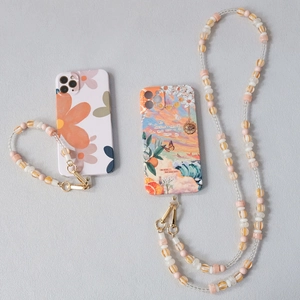Detail view of colorful acrylic beaded crossbody phone straps with artistic floral cases