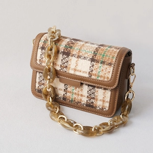 Détail du sac bandoulière en tweed vintage avec chaîne acrylique ambre et détails dorés