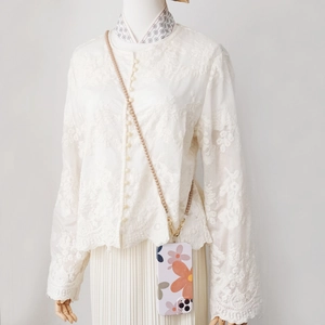 Détail de la bandoulière en perles beiges avec coque de téléphone à fleurs roses