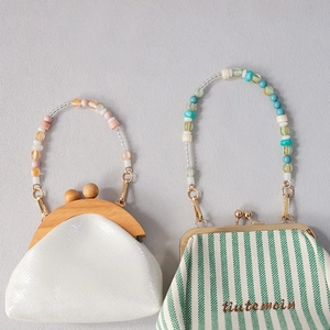 Detail of acrylic bead handles on leather and striped canvas mini purses with kiss lock