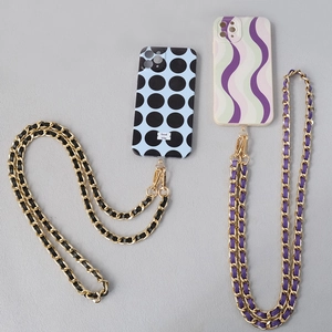 Detailed view of leather-threaded metal chains on polka dot and wave patterned phone cases