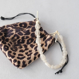 Detail of white acrylic beaded strap with irregular pearls and leopard print pouch
