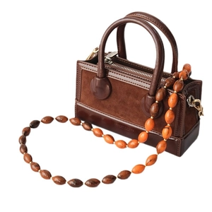 Sac à main marron en daim et cuir verni avec une chaîne élégante en acrylique
