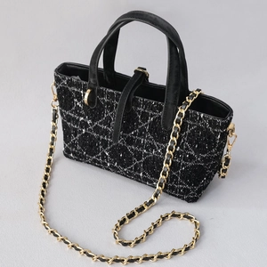 Detail showing elegant black and white tweed bag with golden chain and classic cannage stitching