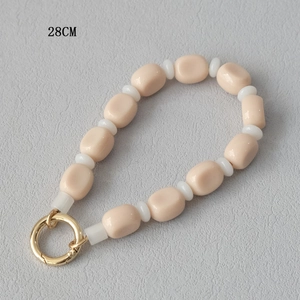 Close-up of 28cm matte pink acrylic beads with gold spring ring clasp for handbags