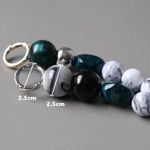 Detail showing 2.5cm colorful marble resin beads and silver ring on a handmade bag strap