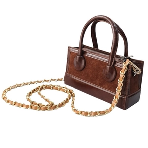 Brown mini suede handbag with golden metal chain strap and top handle on white background