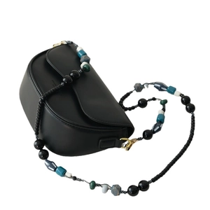 Sacoche selle en cuir noir mat avec bandoulière en perles colorées et détails dorés