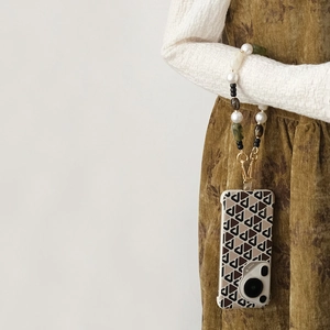 Handcrafted acrylic beaded phone strap with pearls and green stones on a geometric case