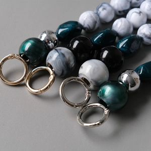 Detailed macro view of acrylic beaded bag straps with colorful resin beads and metal ring clasps