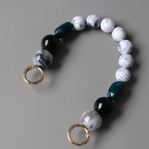 Detail showing acrylic resin beaded bag chain with marble pattern and gold metal clasps