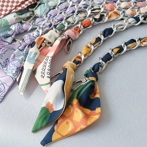 Close-up of stylish silk scarf handbag chains with diverse patterns and metal clasps