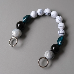 Detailed macro view of acrylic marble and green resin beads with silver spring rings