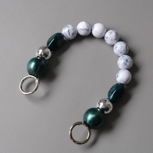 Macro detail of acrylic resin beads and marble patterns with silver metal ring clasp