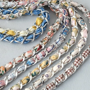 Close-up of assorted silk scarf interwoven metal chains for handbag straps