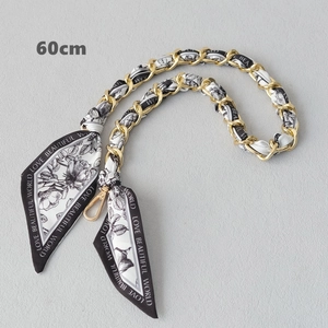 Close-up of a 60cm gold chain strap woven with a black and white floral silk scarf