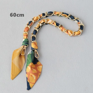 Close-up of a 60cm gold chain interwoven with a yellow and green pineapple print scarf