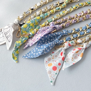 Golden metal chain shoulder straps interwoven with colorful floral silk scarves for handbags