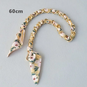 Close-up of 60cm gold chain interwoven with floral silk scarf for handbags