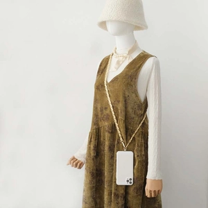 White smartphone case with golden braided crossbody chain worn as a stylish fashion accessory